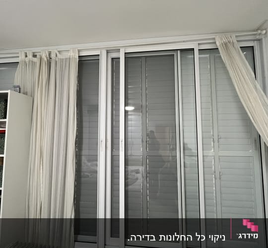וילונות לבנים על חלון גדול עם תריסים
